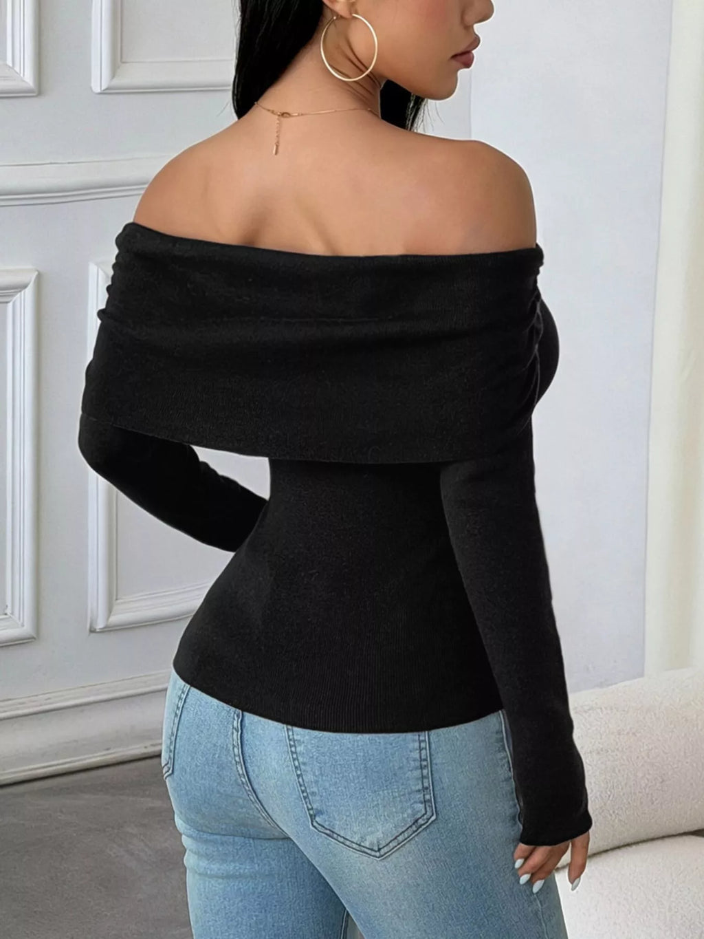 Elegant off-shoulder ribbed knit top worn by a model, showcasing its slim-fit design and ribbed texture.