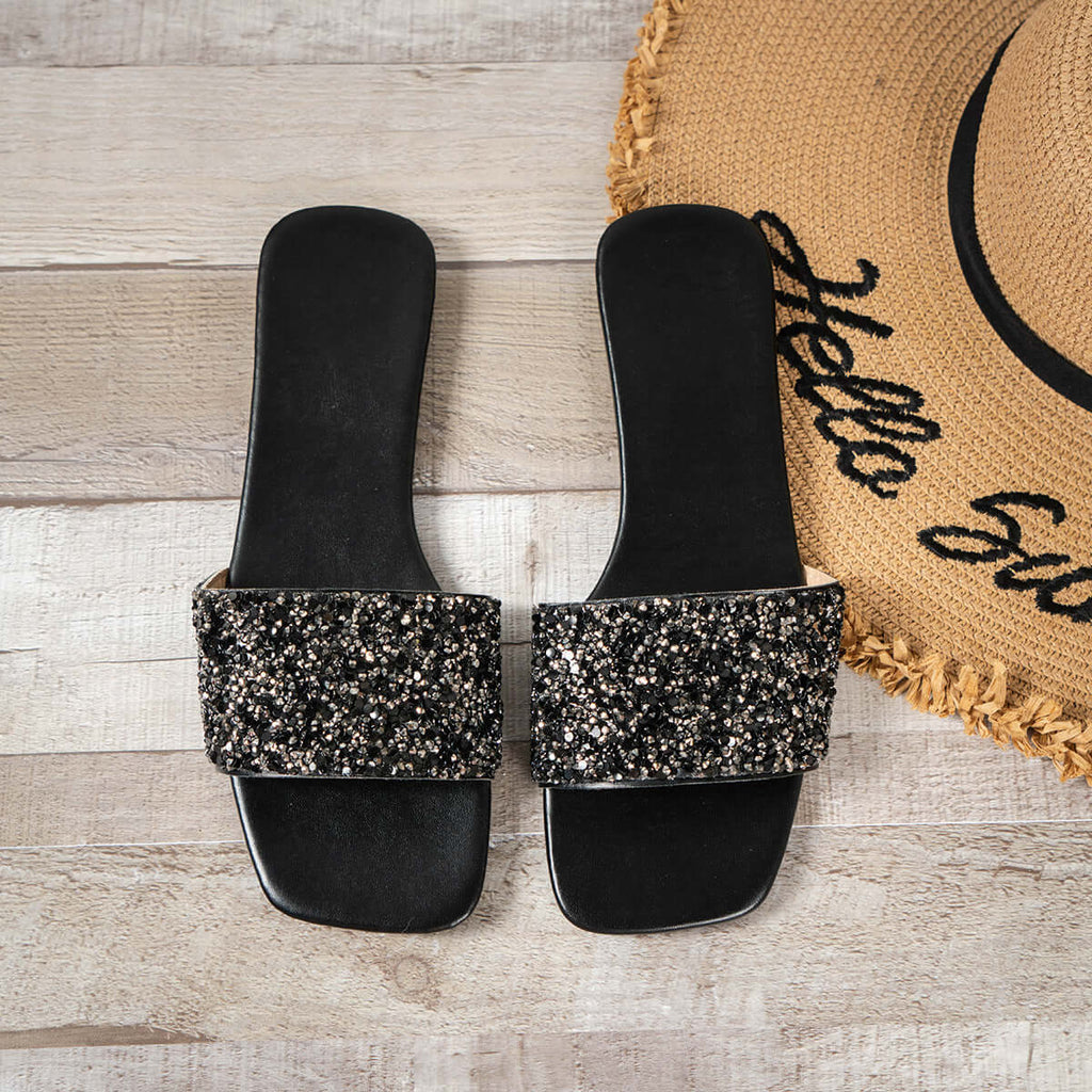 Women's open toe sandals with rhinestone detail on a stylish black background.