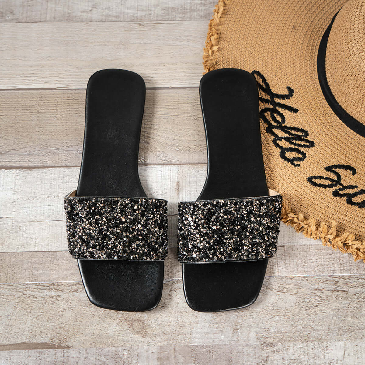 Women's open toe sandals with rhinestone detail on a stylish black background.