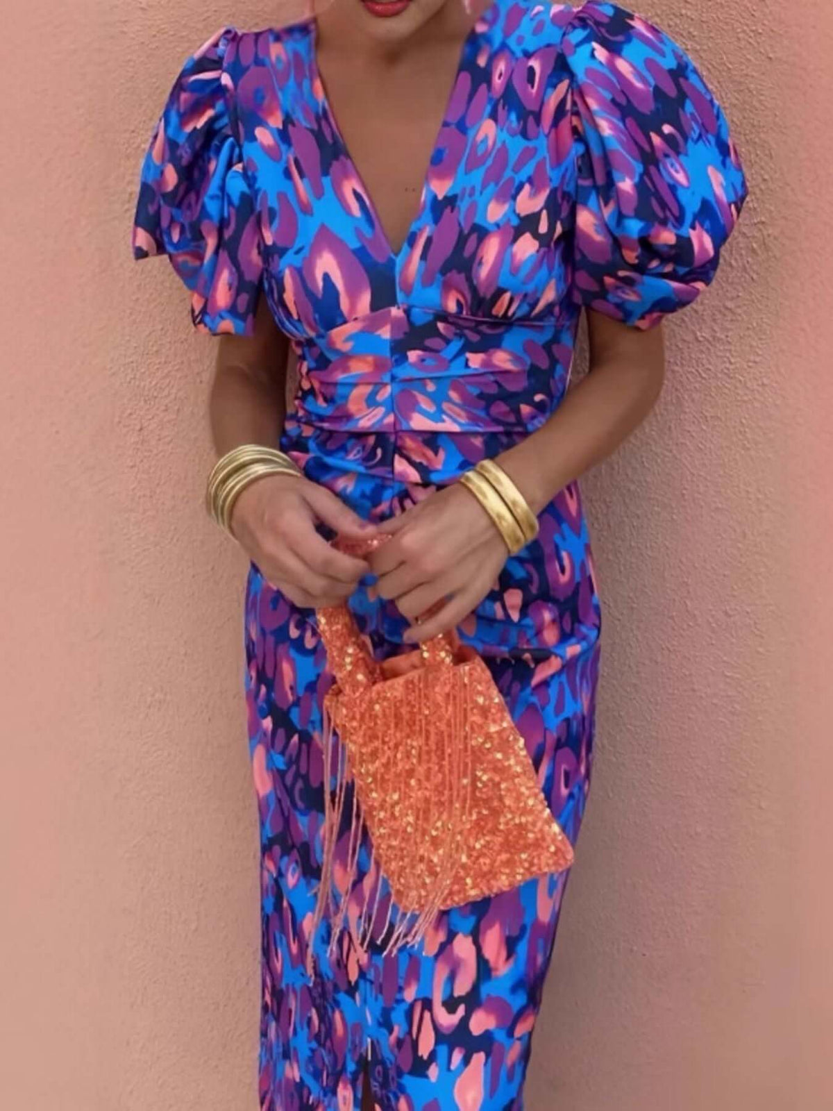 Model wearing a vibrant plus size puff sleeve midi dress with an orange bag, showcasing style and elegance.