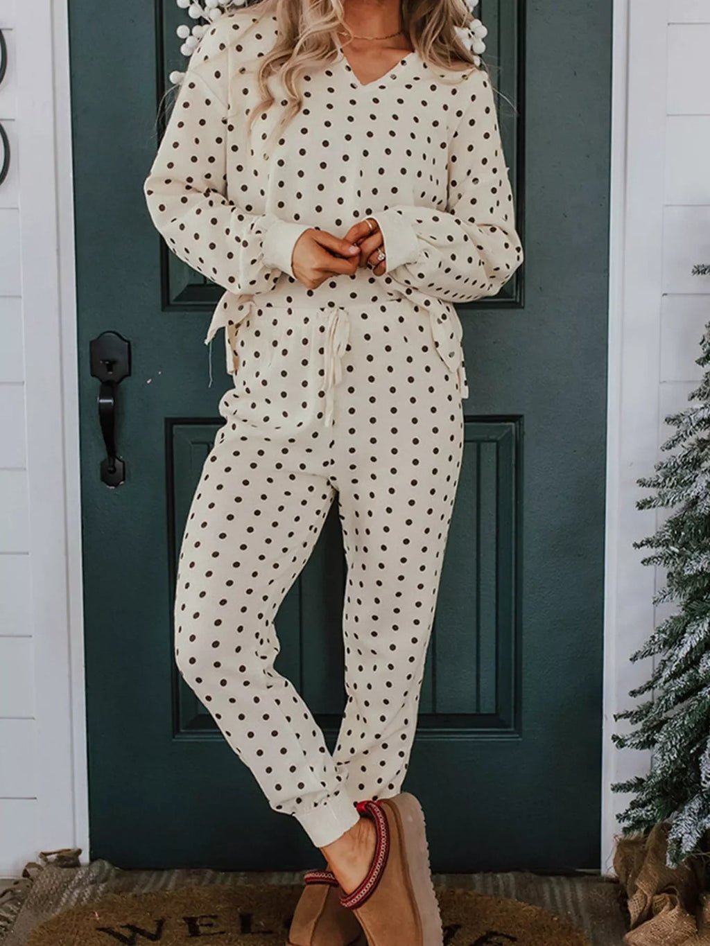 Model wearing Polka Dot Notched Long Sleeve Top and Drawstring Joggers Lounge Set in a cozy setting.