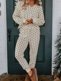 Model wearing Polka Dot Notched Long Sleeve Top and Drawstring Joggers Lounge Set in a cozy setting.