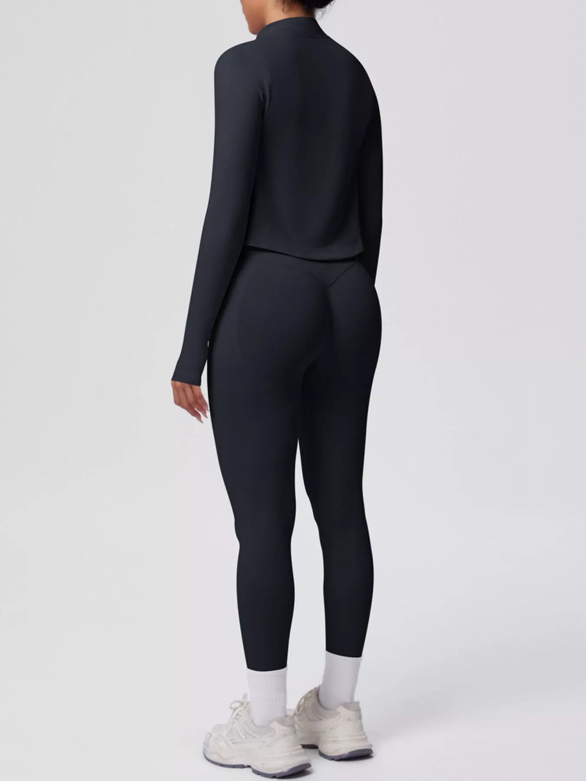 Stylish activewear set featuring a tank top and zip-up jacket with leggings in a sleek black design.