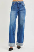 Blue Wash High Rise Wide Leg Jeans with cuffed hems and relaxed silhouette on model.