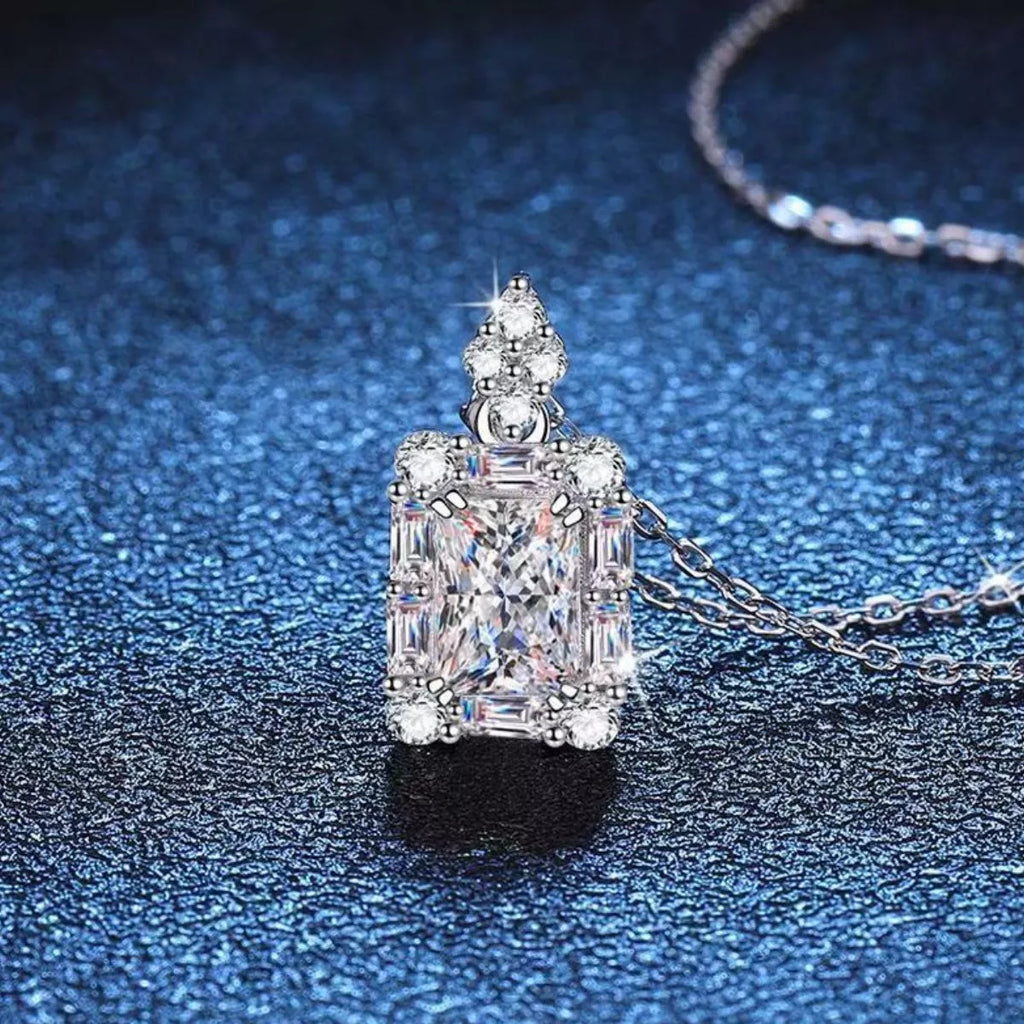Moissanite jewelry 1 carat pendant necklace on a blue background, showcasing brilliance and elegance.