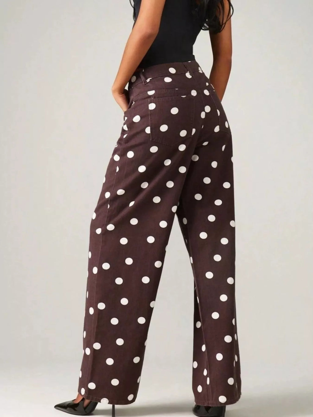 Trendy polka dot wide-leg jeans showcasing a stylish back view with white polka dots on a dark background.
