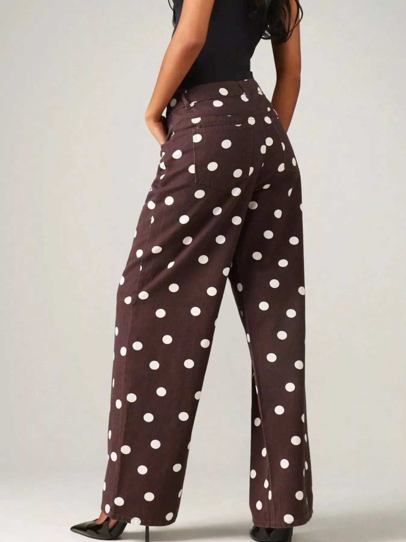 Trendy polka dot wide-leg jeans showcasing a stylish back view with white polka dots on a dark background.
