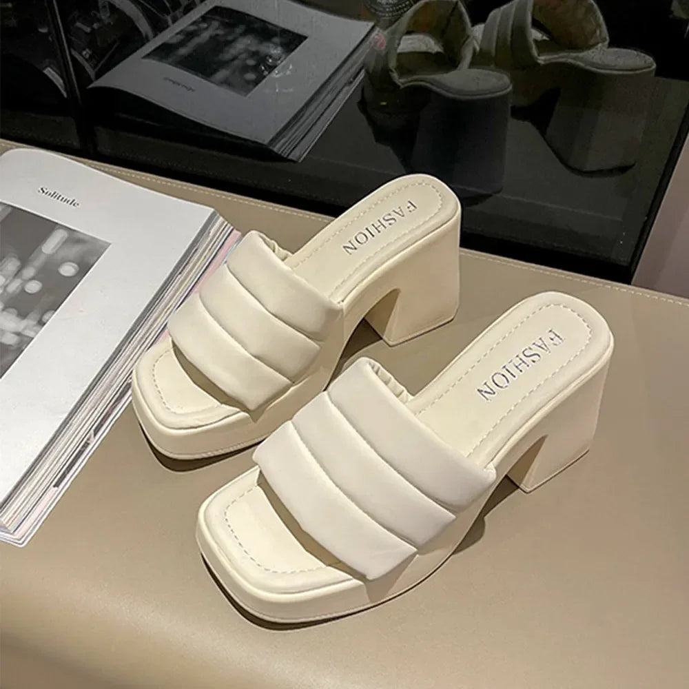 Open Toe Block Heel Sandals in cream color with padded straps and block heels on a stylish table.