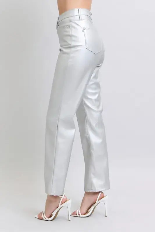 Side view of plus size high waist faux leather pants in silver, styled with trendy heels.
