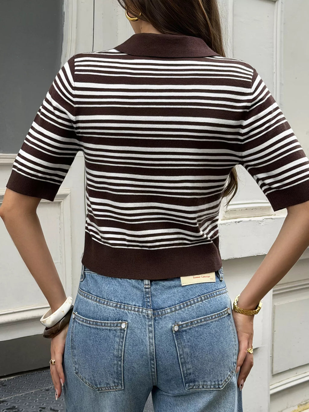 Back view of women's cropped polo with stripes, featuring a striped design and slightly stretchy knit fabric.