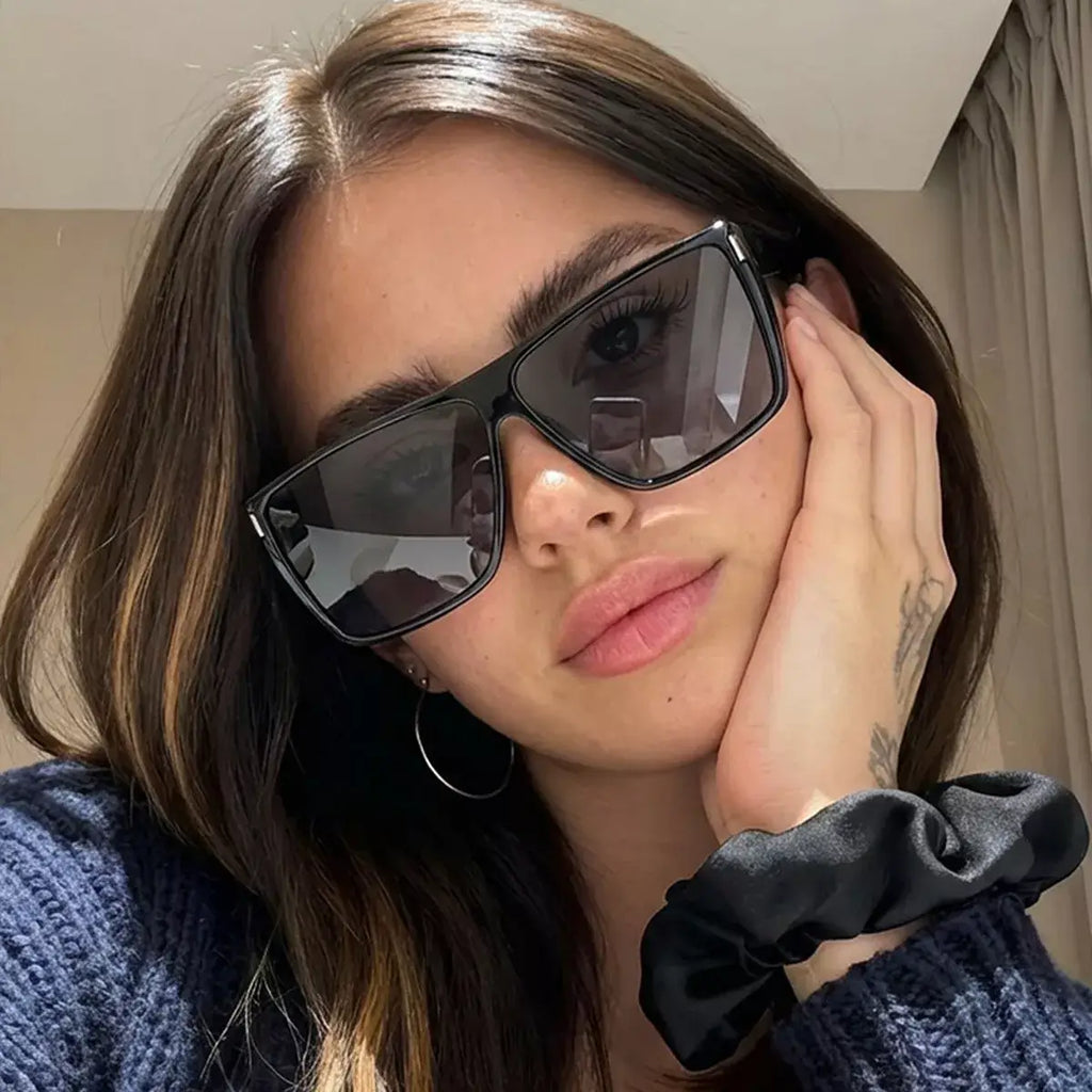 Close-up of a model wearing oversized square sunglasses for a stylish look.