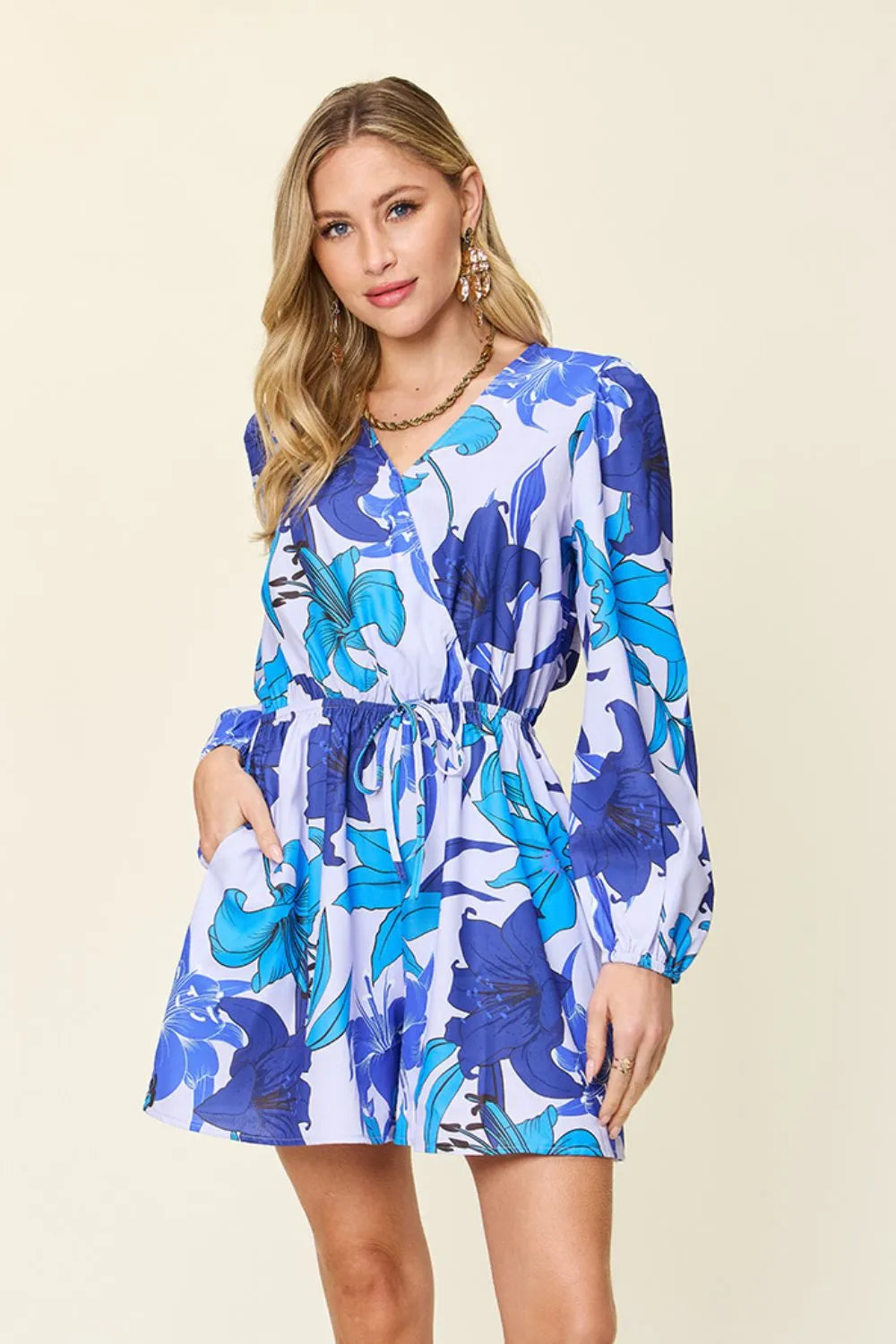 Women's floral romper with pockets featuring a vibrant blue floral design, perfect for any stylish occasion.