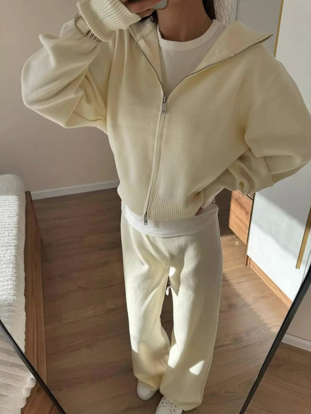 Stylish model wearing plush zip-up hoodie and pants set in cream, showcasing cozy two-piece outfit ideal for casual wear.