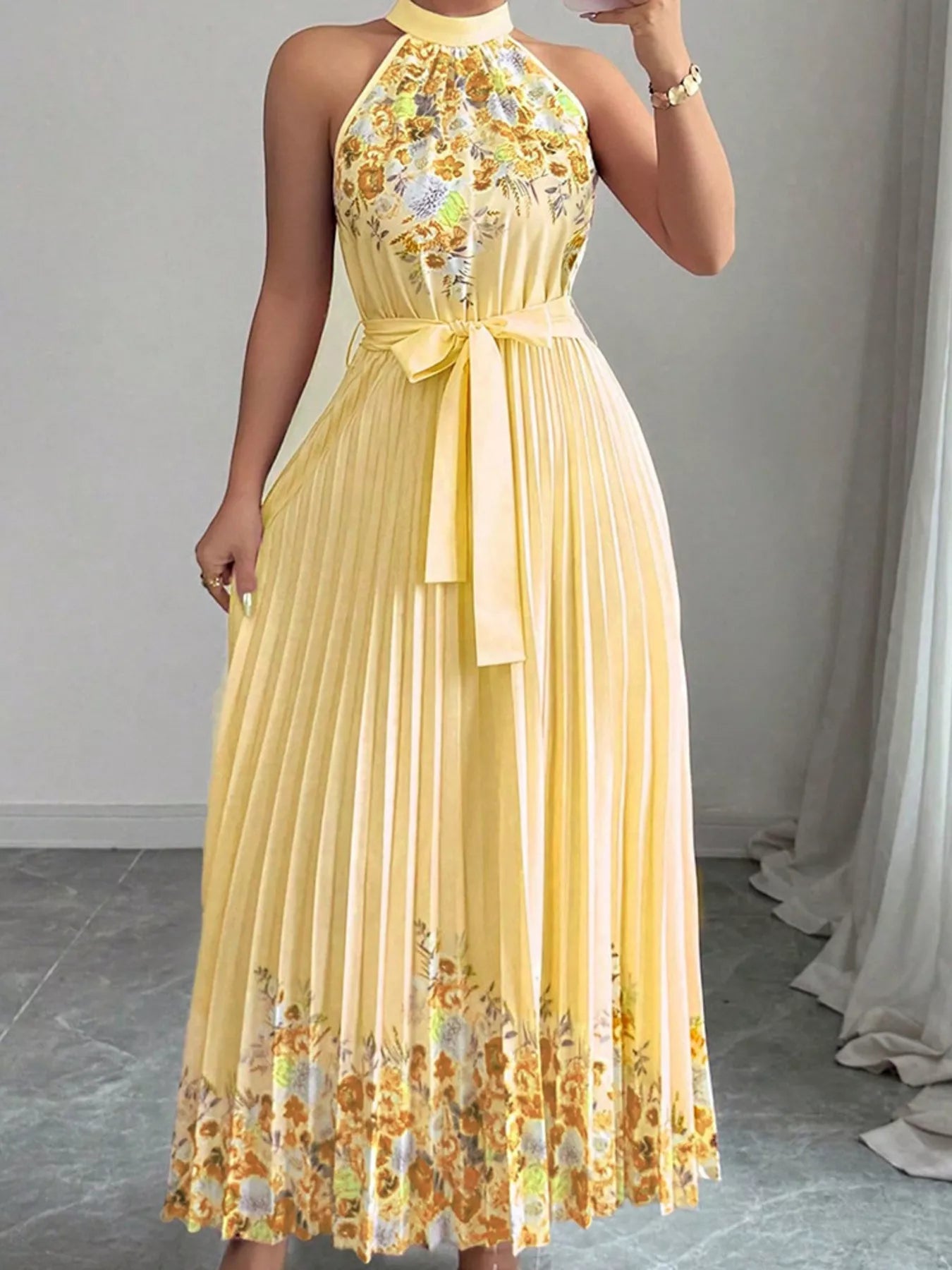 Summer maxi dress with halter neck and floral print pleated design in yellow, ideal for warm-weather occasions.