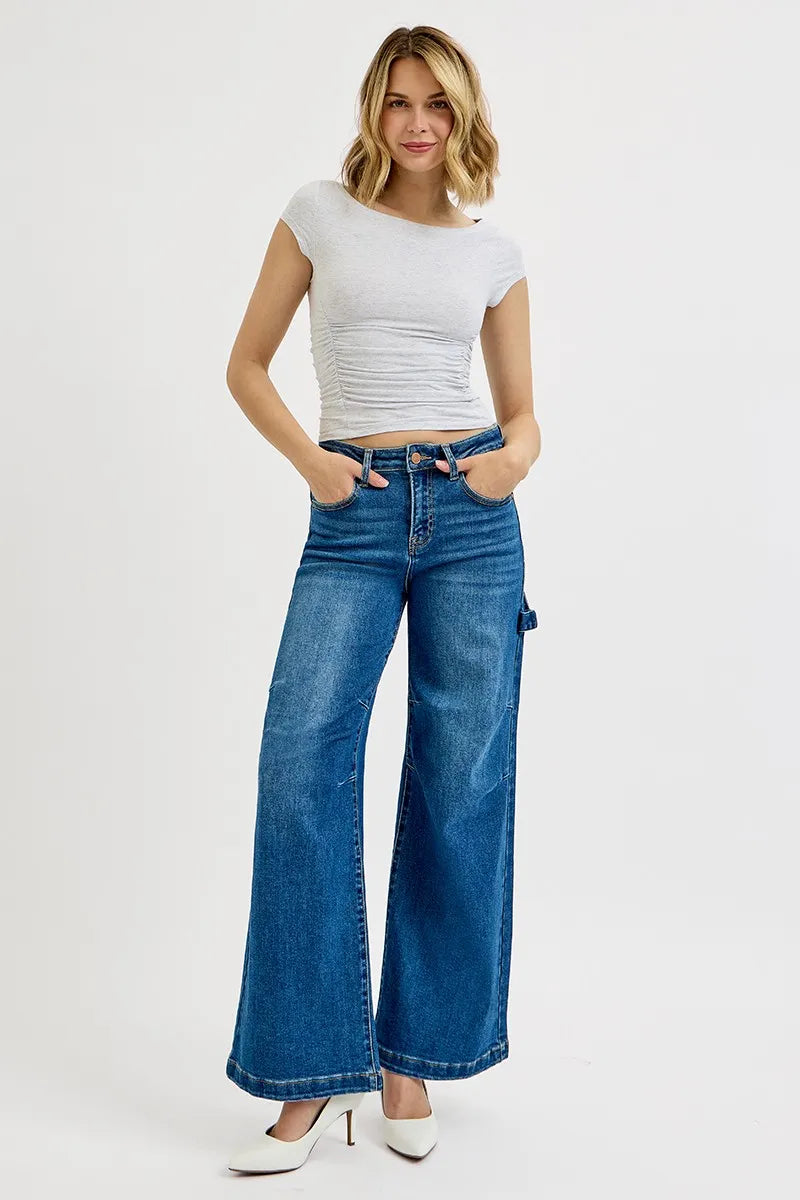 Model wearing affordable plus size jeans featuring high rise, wide leg, and patch detailing.