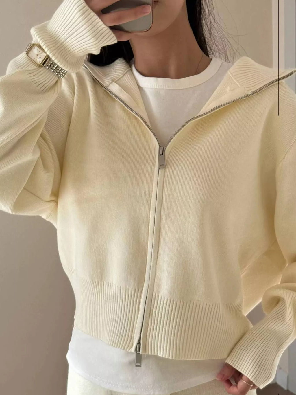 Model wearing a plush zip-up hoodie and pants set in cream color, showcasing cozy and stylish design.