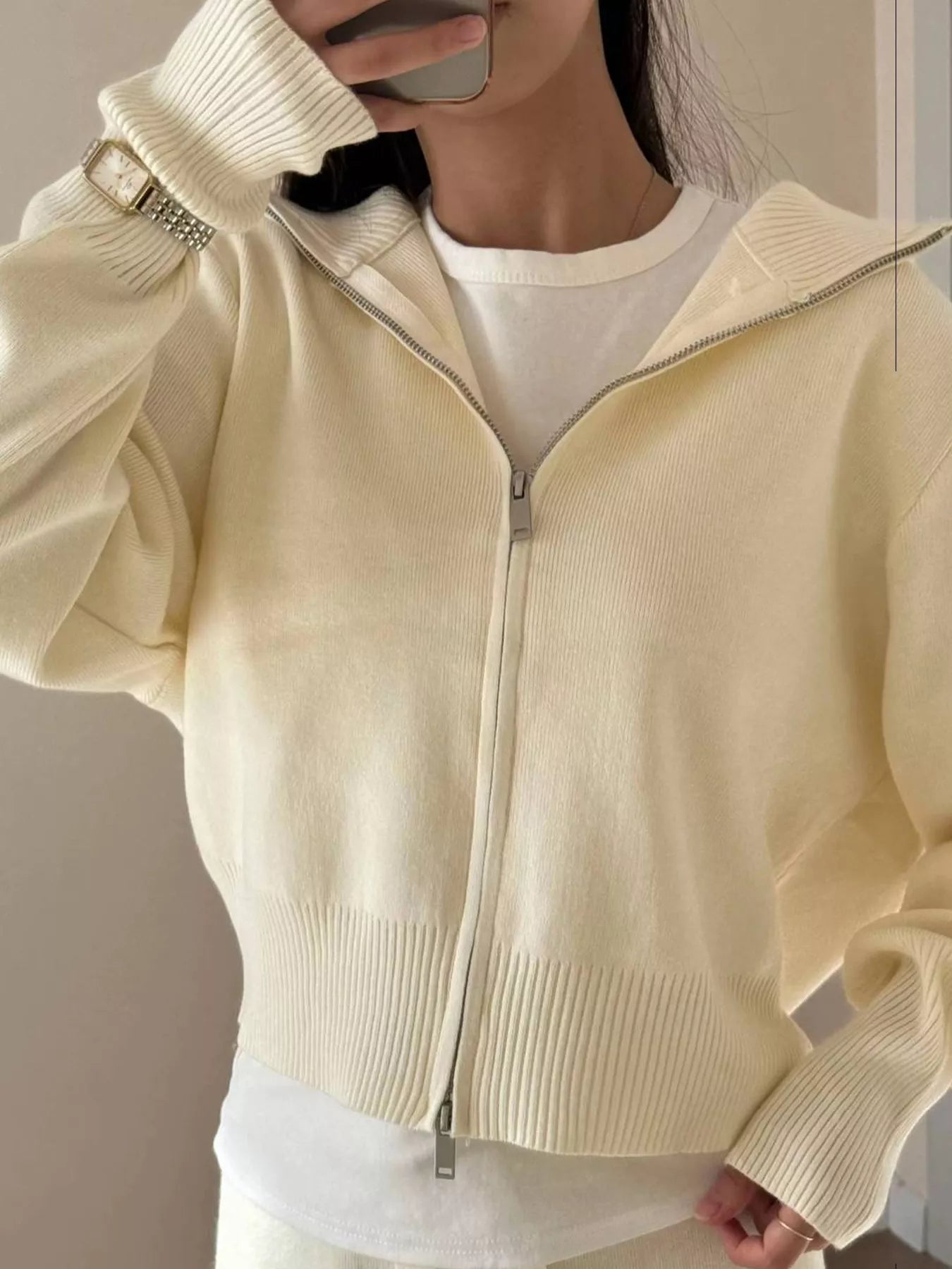 Model wearing a plush zip-up hoodie and pants set in cream color, showcasing cozy and stylish design.