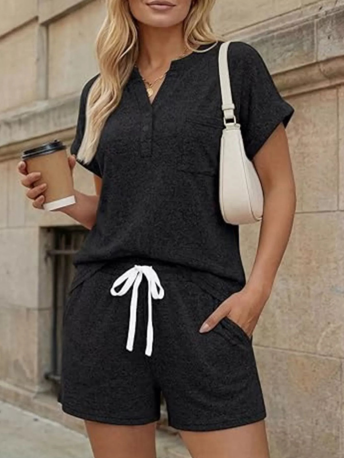 Woman wearing a matching top and shorts set, featuring a pocketed design, drawstring shorts, and a casual style.