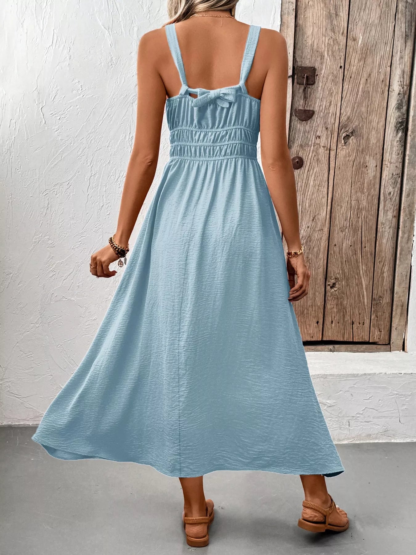 Midi dress for women with sleeveless design and smocked back in light blue color.
