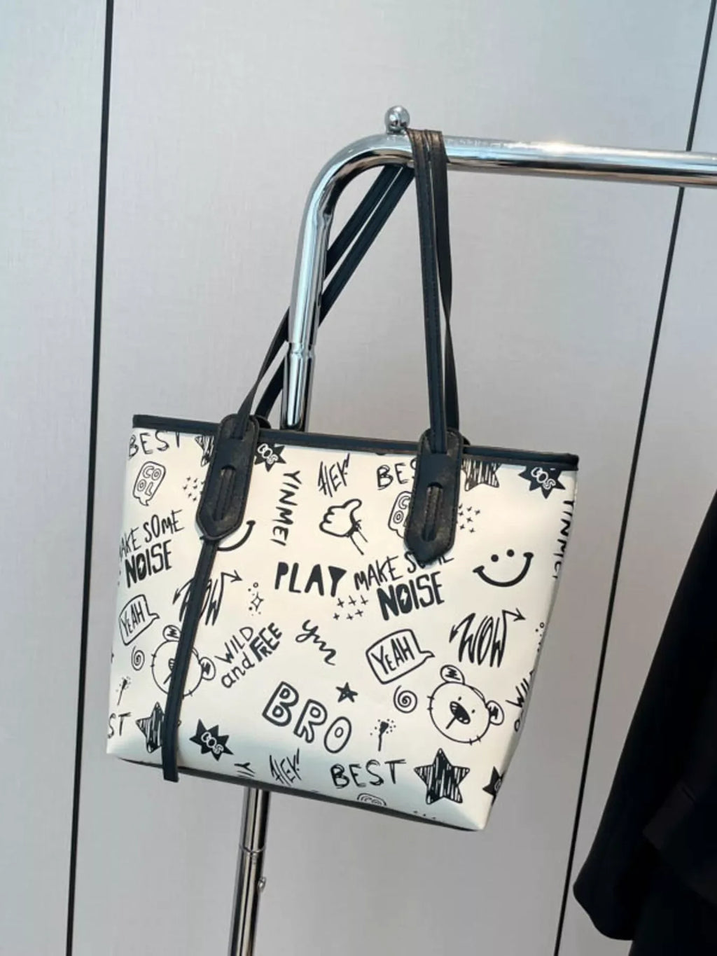 Graffiti Print Tote Bag – Large Canvas Shoulder Bag for Women hanging on a rack with artistic black and white designs.