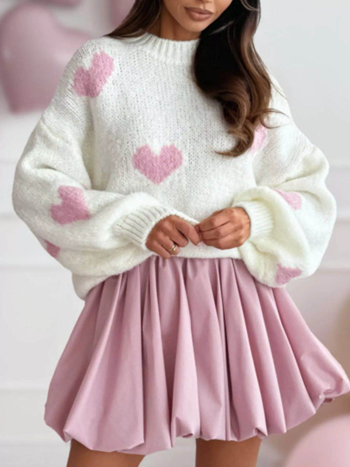 Heart Round Neck Knitted Sweater styled with a pink skirt, featuring heart patterns and a cozy design.