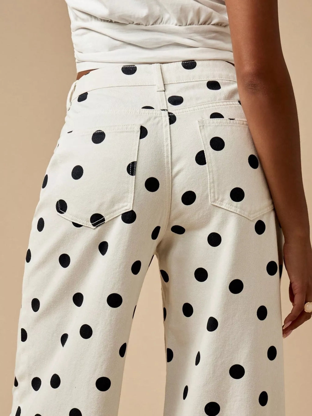 Back view of trendy polka dot wide-leg jeans showcasing pockets and playful polka dot design.