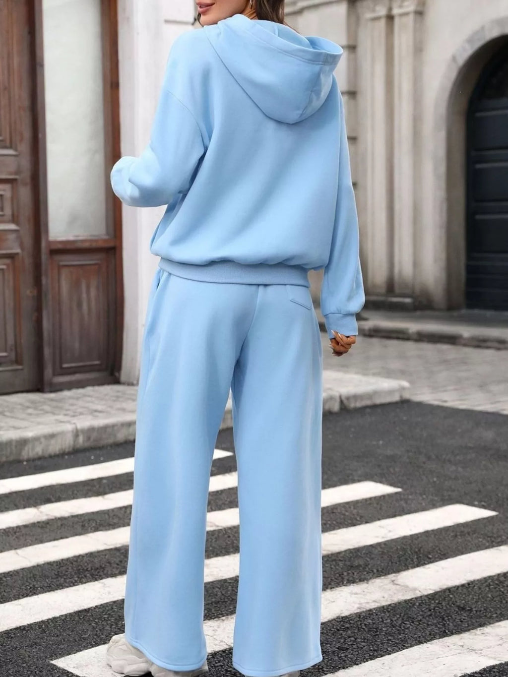 Woman wearing a light blue hoodie and pant set - wide leg, showcasing comfort and style.