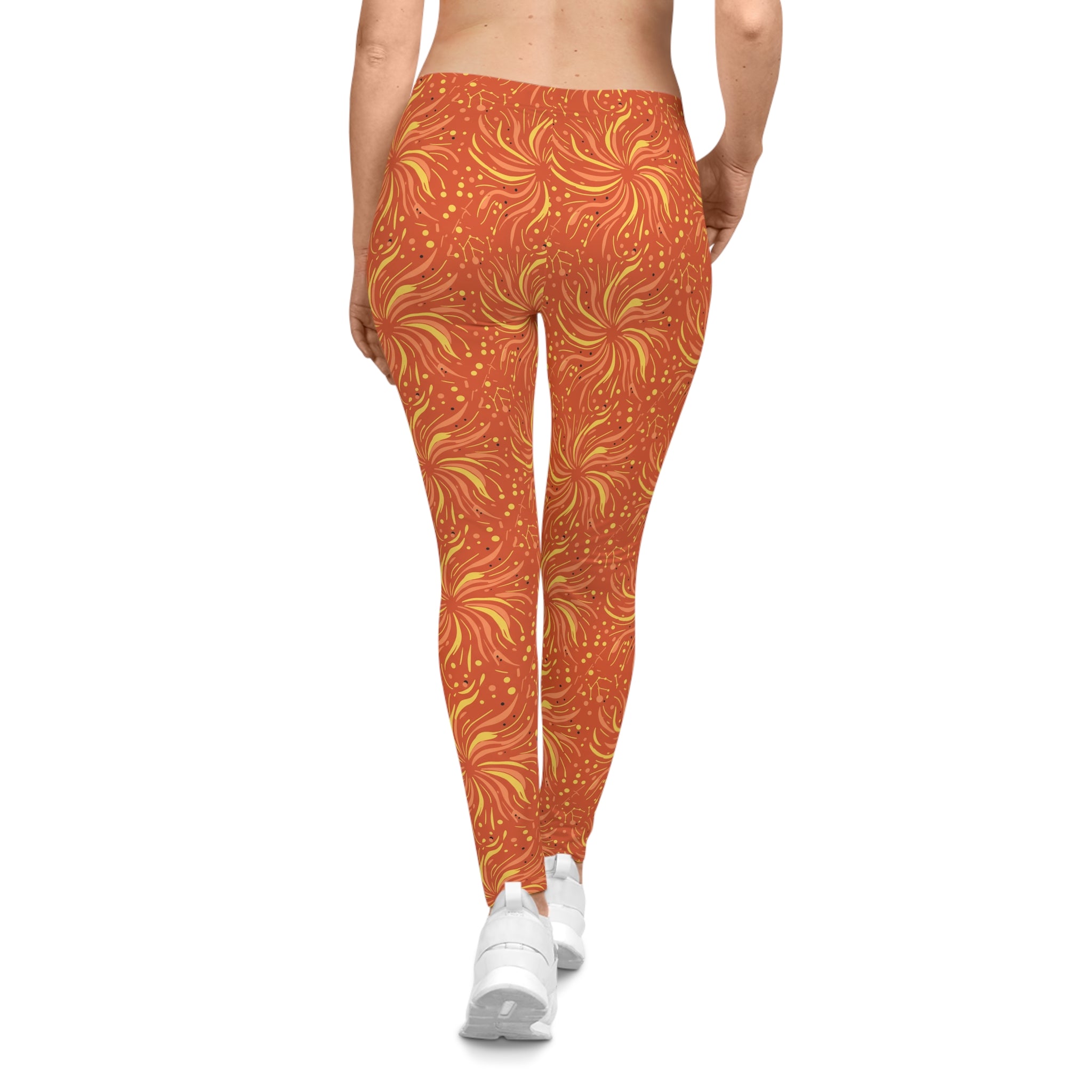 Back view of woman wearing Leo constellation leggings with sunset-orange base and golden sunbursts design.