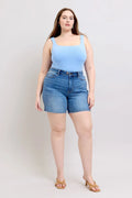 Plus Size Denim Shorts (S–3XL) | 2-Button Stretch Shorts on a model wearing a blue top and sandals.
