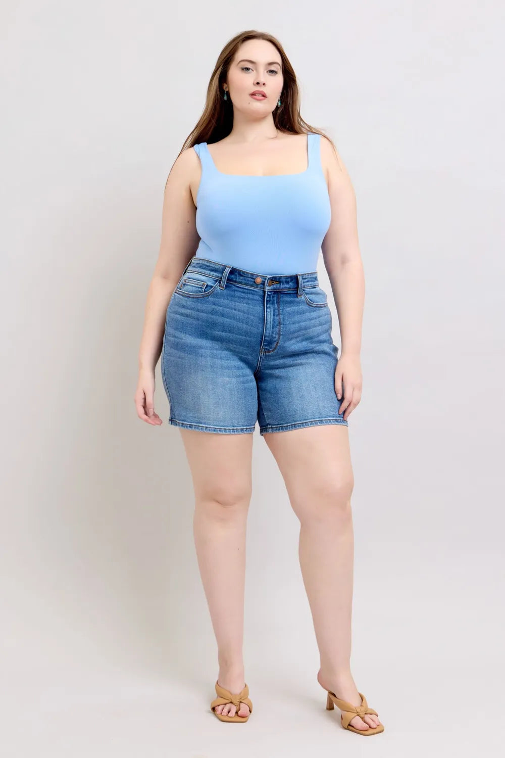 Plus Size Denim Shorts (S–3XL) | 2-Button Stretch Shorts on a model wearing a blue top and sandals.