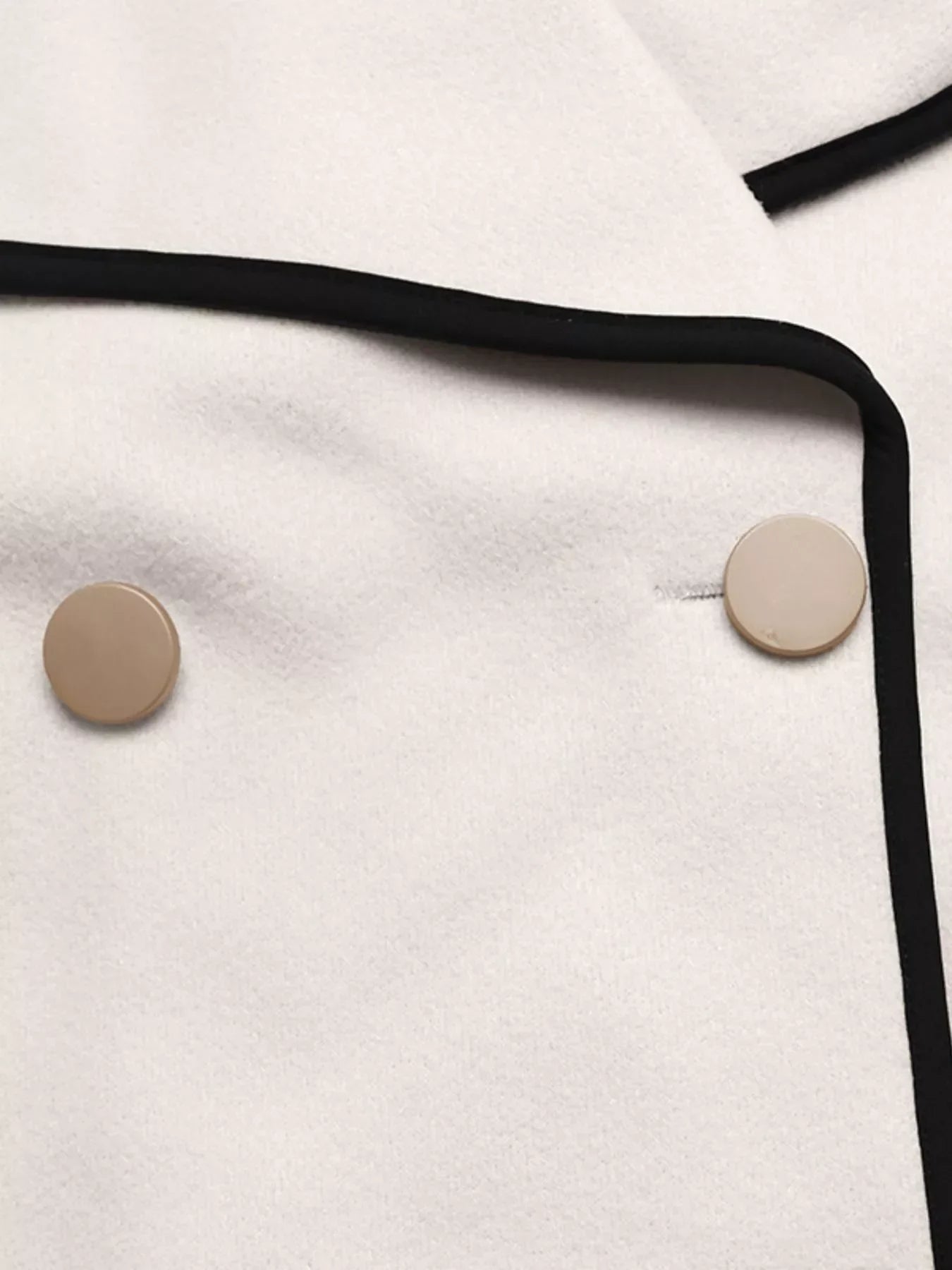 Close-up of the Contrast Trim Double-Breasted Jacket showcasing buttons and bold contrast trim.