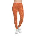 Woman wearing Leo constellation leggings with sunset-orange base and golden sunburst pattern.