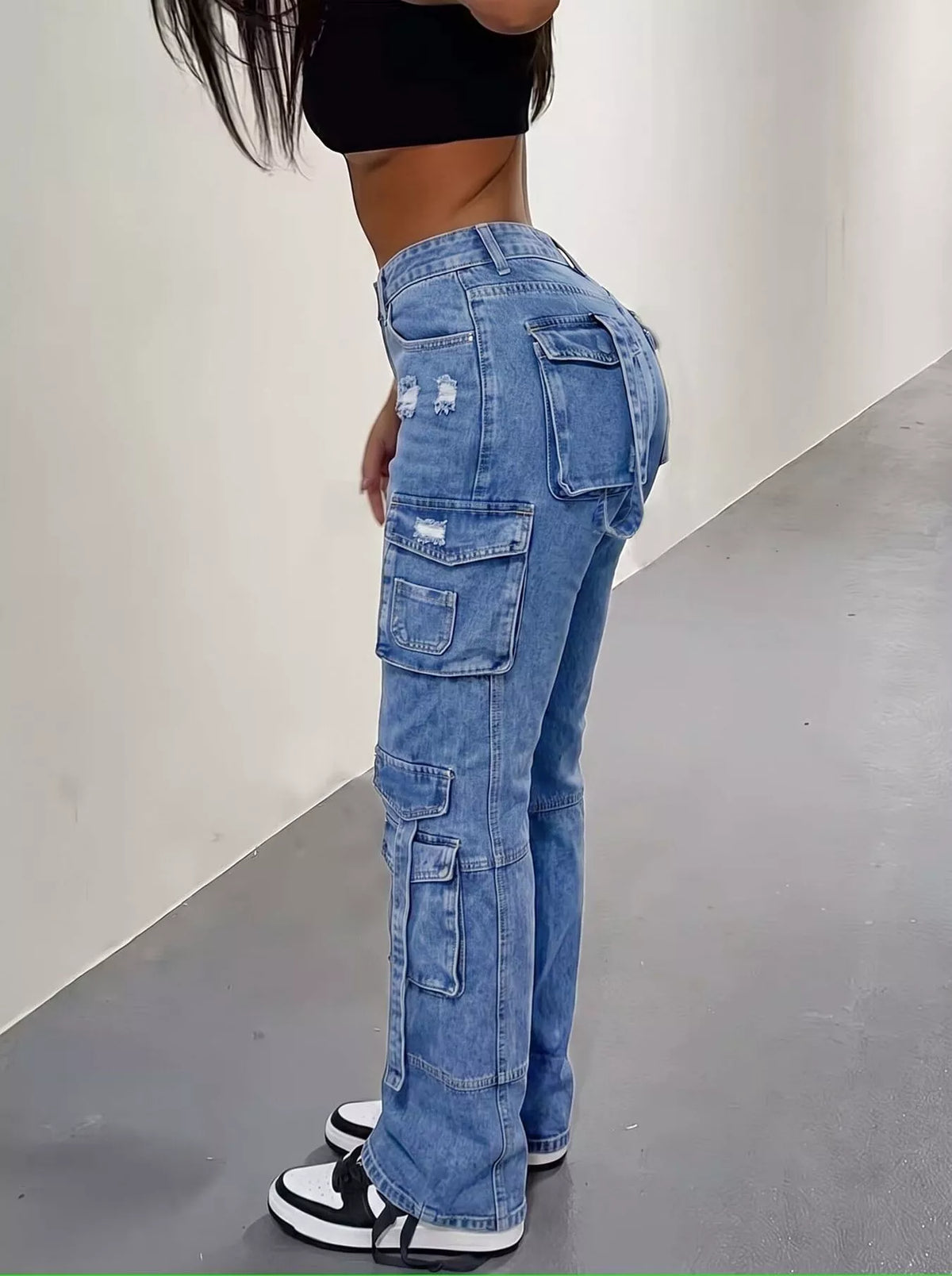 Trendy cargo jeans in distressed style worn by a model, showcasing a high-waisted fit and chic street style.
