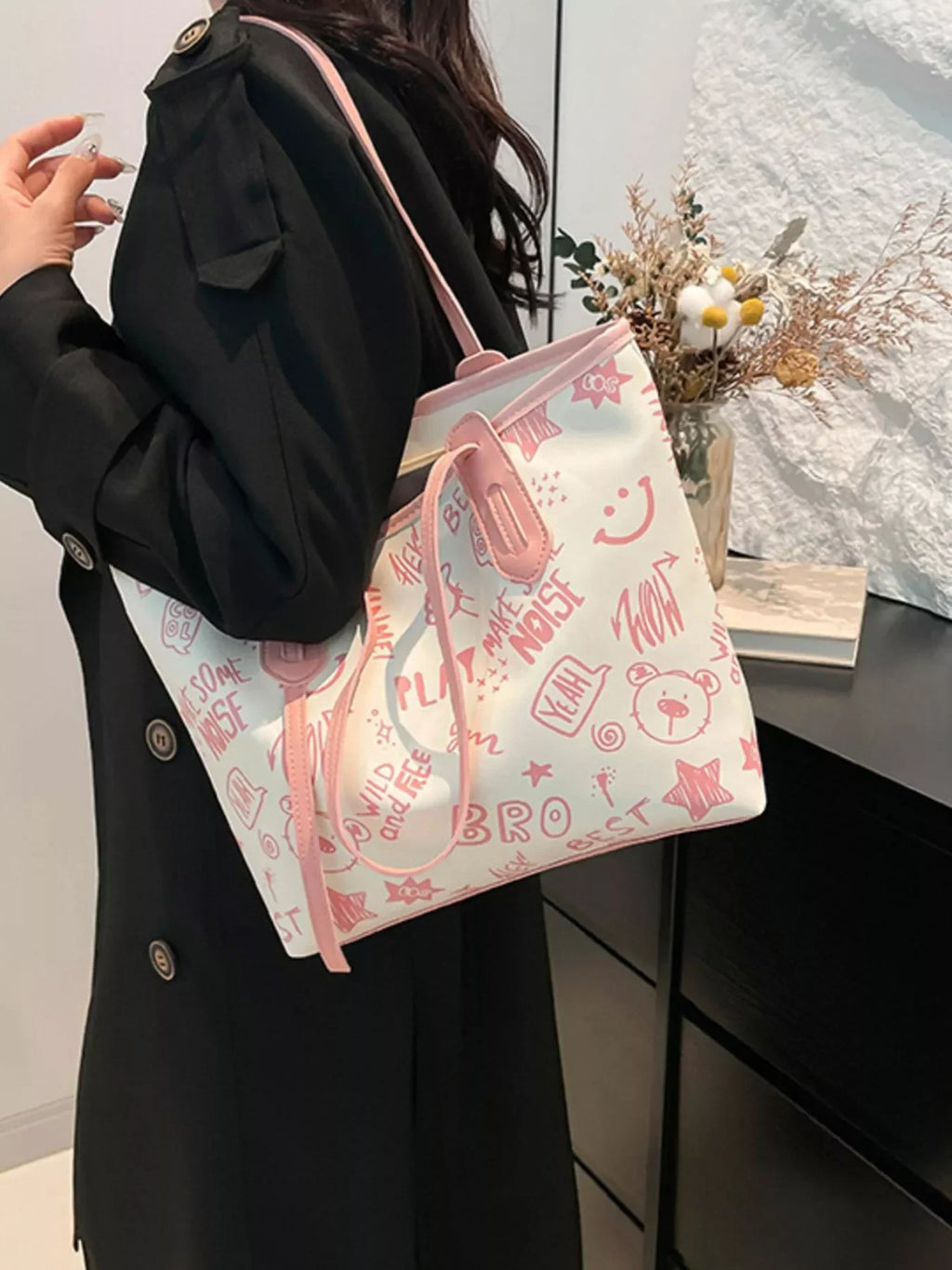Graffiti Print Tote Bag – Large Canvas Shoulder Bag for Women being carried stylishly by a woman in a black coat.