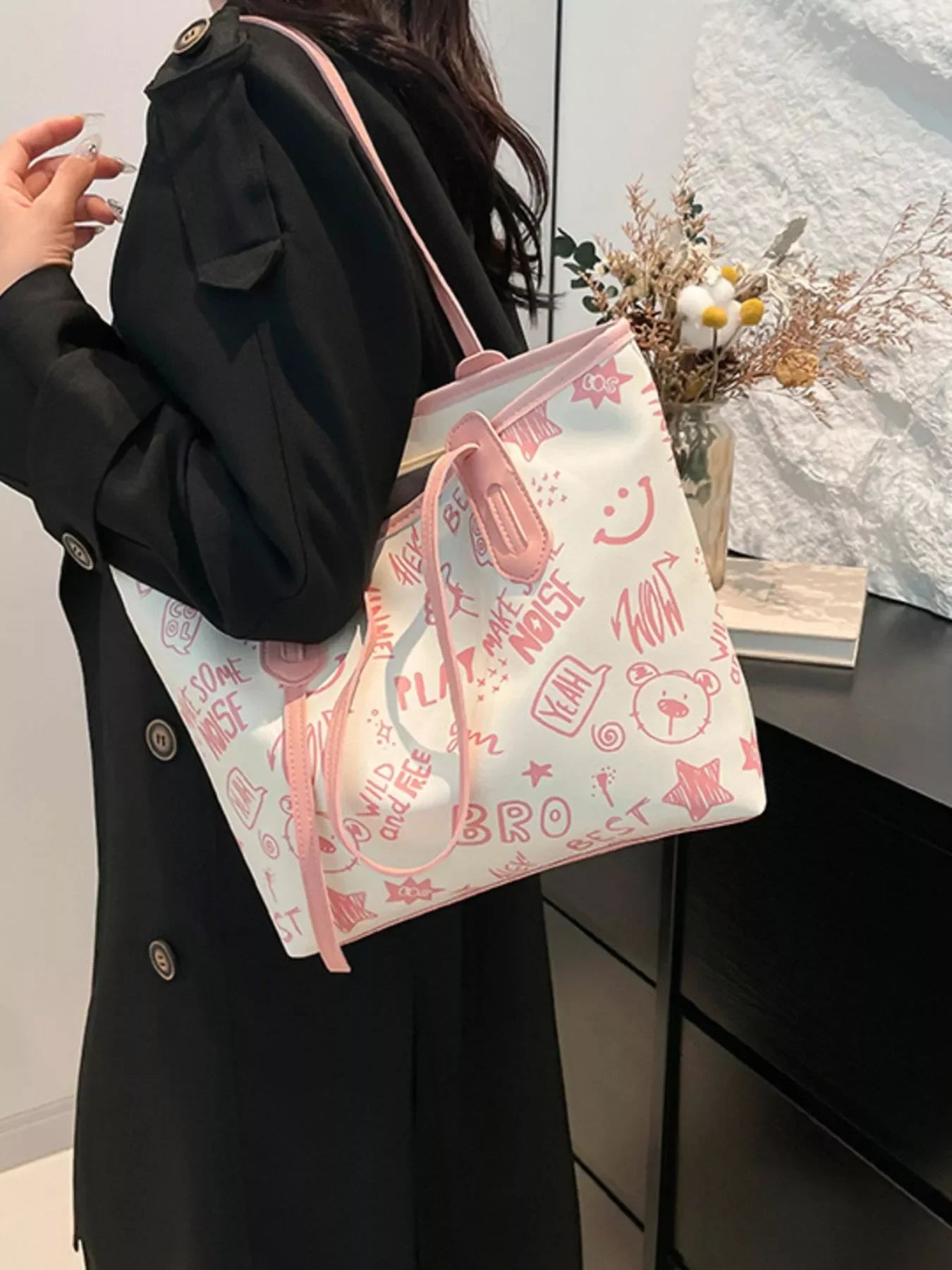Graffiti Print Tote Bag – Large Canvas Shoulder Bag for Women being carried stylishly by a woman in a black coat.