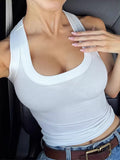 Ribbed tank top in white, showcasing stretchy fabric and stylish design, worn with high-waisted jeans.