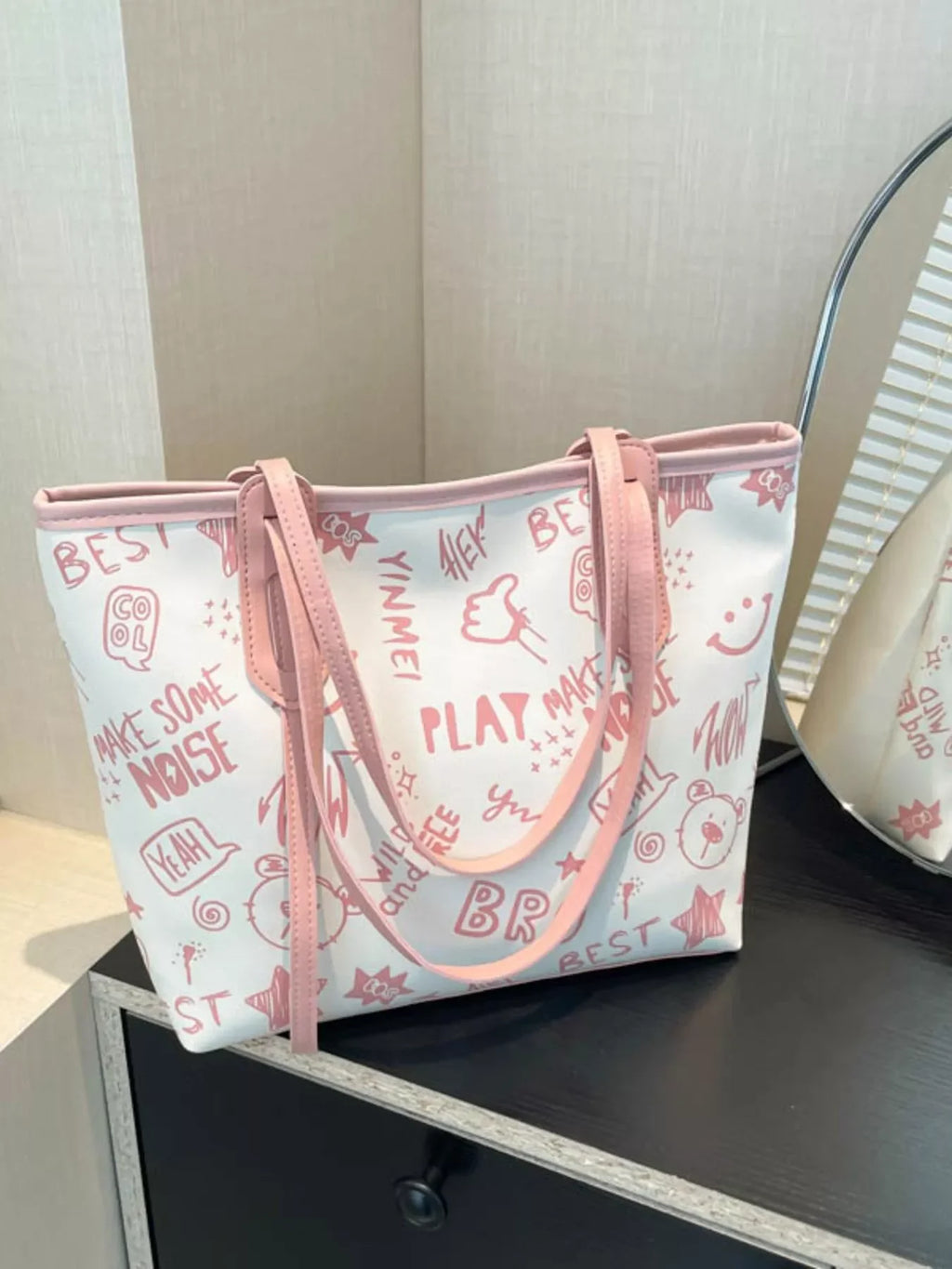 Graffiti Print Tote Bag – Large Canvas Shoulder Bag for Women displayed on a table next to a mirror.