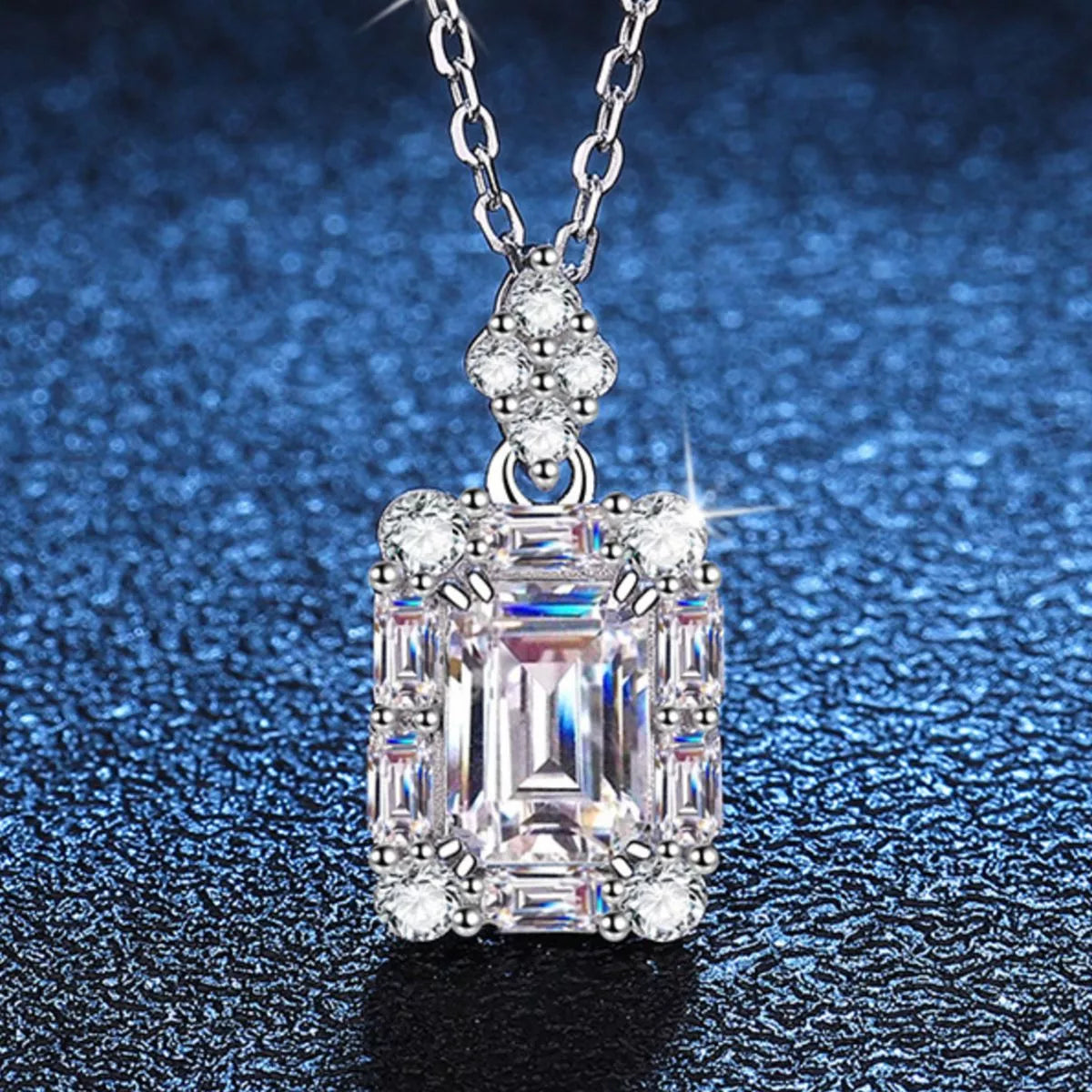 Stunning moissanite jewelry 1 carat pendant necklace on a silver chain against a shimmering background.