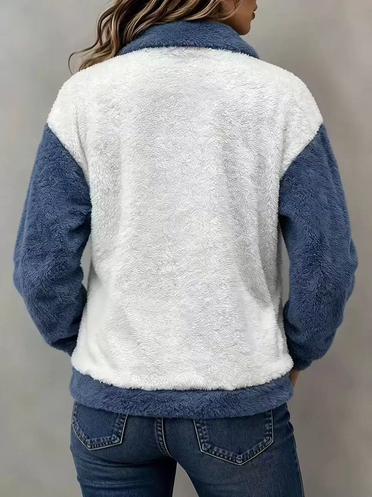 Model showcasing the back of a color-block fuzzy sweatshirt featuring blue and white panels.