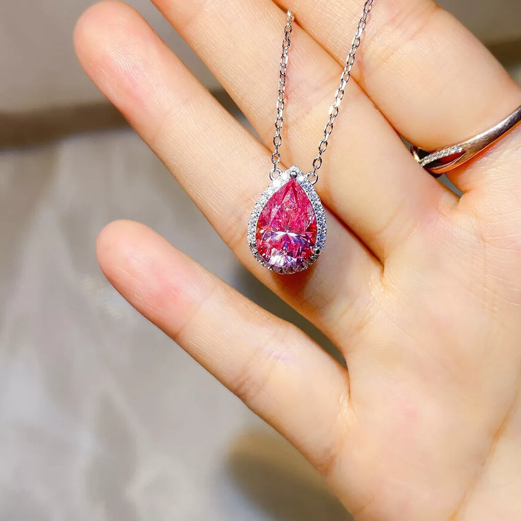 925 sterling silver pendant necklace featuring a stunning pink Moissanite stone held in a hand.