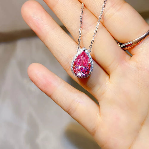 925 sterling silver pendant necklace featuring a stunning pink Moissanite stone held in a hand.