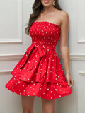 Smocked mini dress in vibrant red with heart patterns and layered skirt, perfect for summer outings.