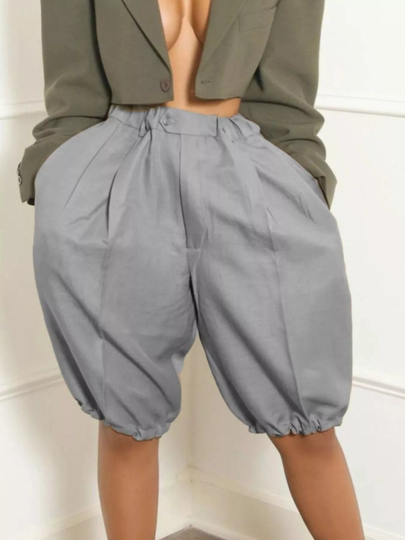 women's pleated shorts in gray, high-waisted design with pockets and drawstring detail.