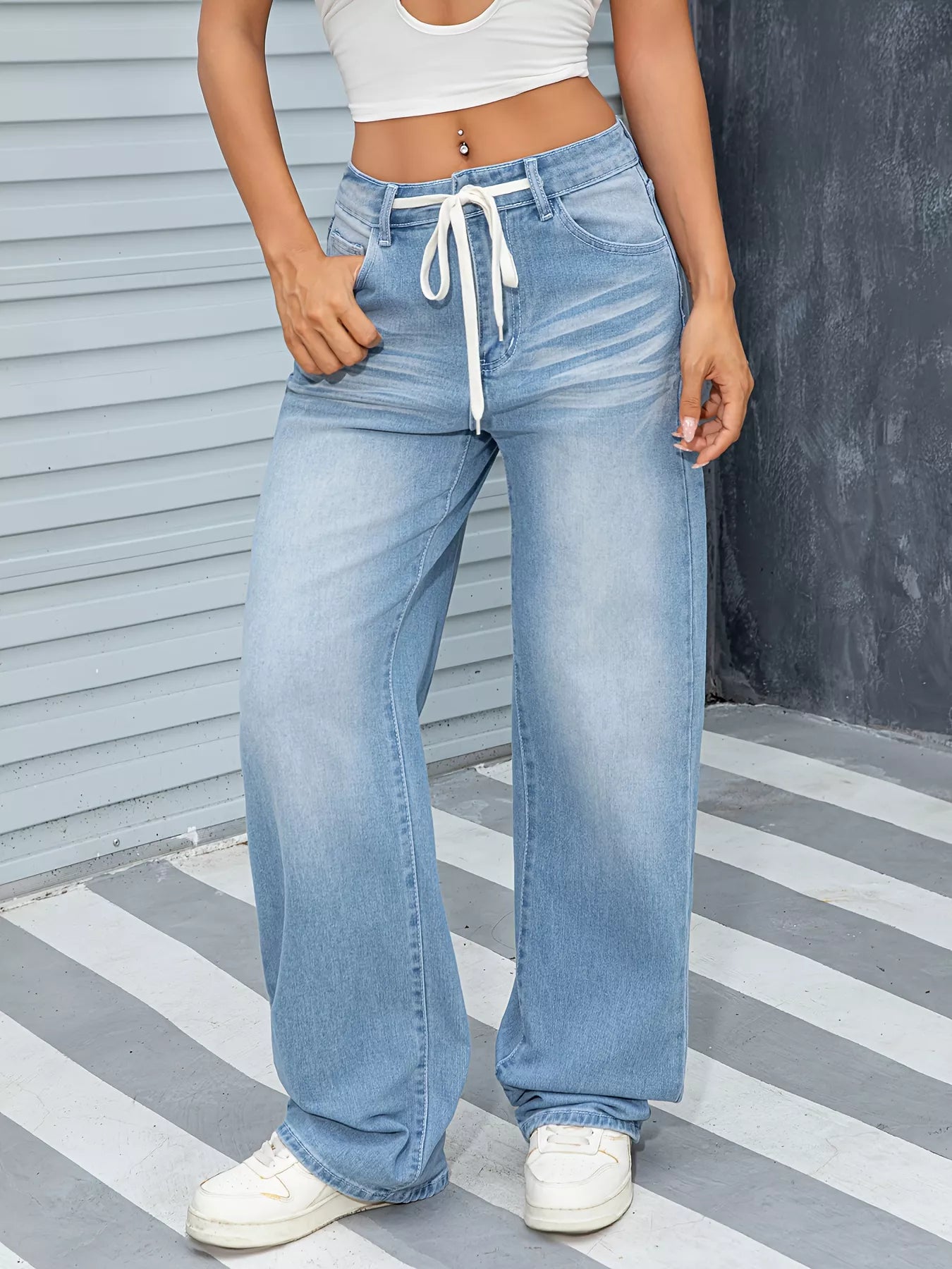 Wide Leg Washed Jeans worn by model, featuring a relaxed silhouette and drawstring detail.
