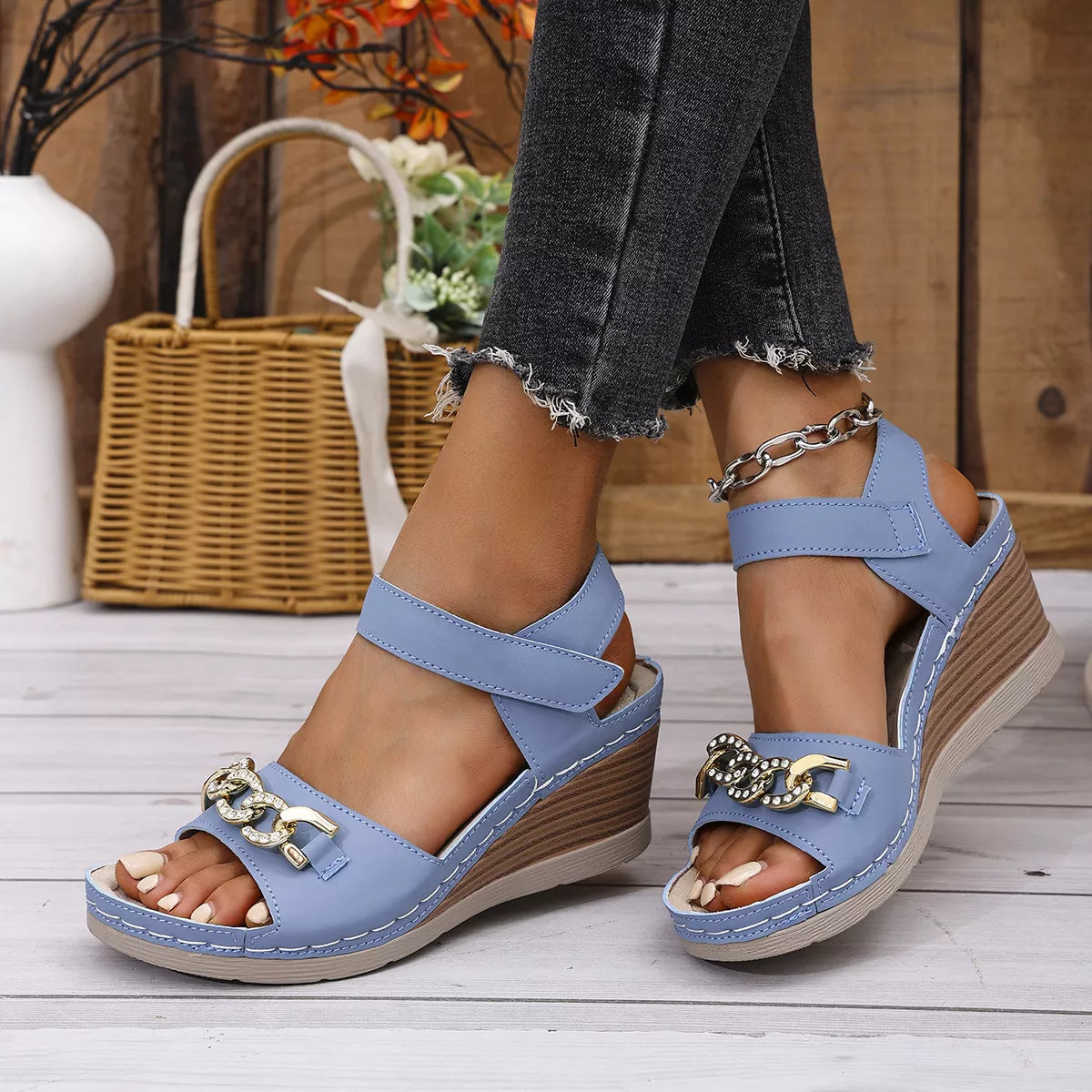 Open toe wedge sandals in sky blue color with decorative chain detail and mid heel, perfect for summer fashion.