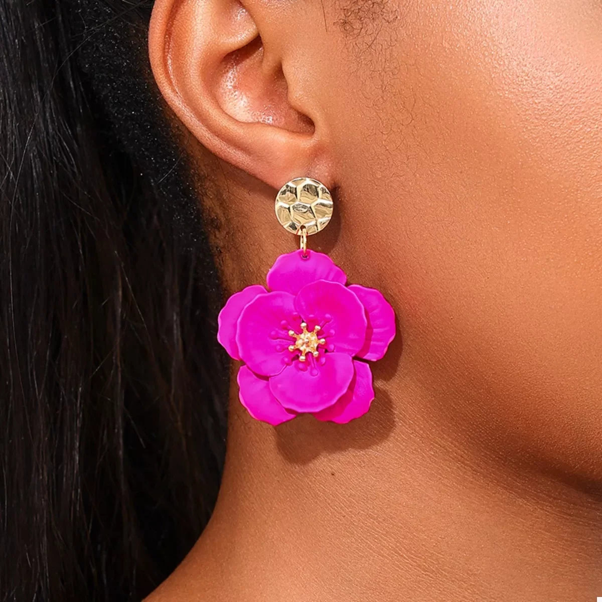 Floral Statement Drop Earrings with Gold Accent showcasing vibrant pink flower design and gold accents on a model's ear.