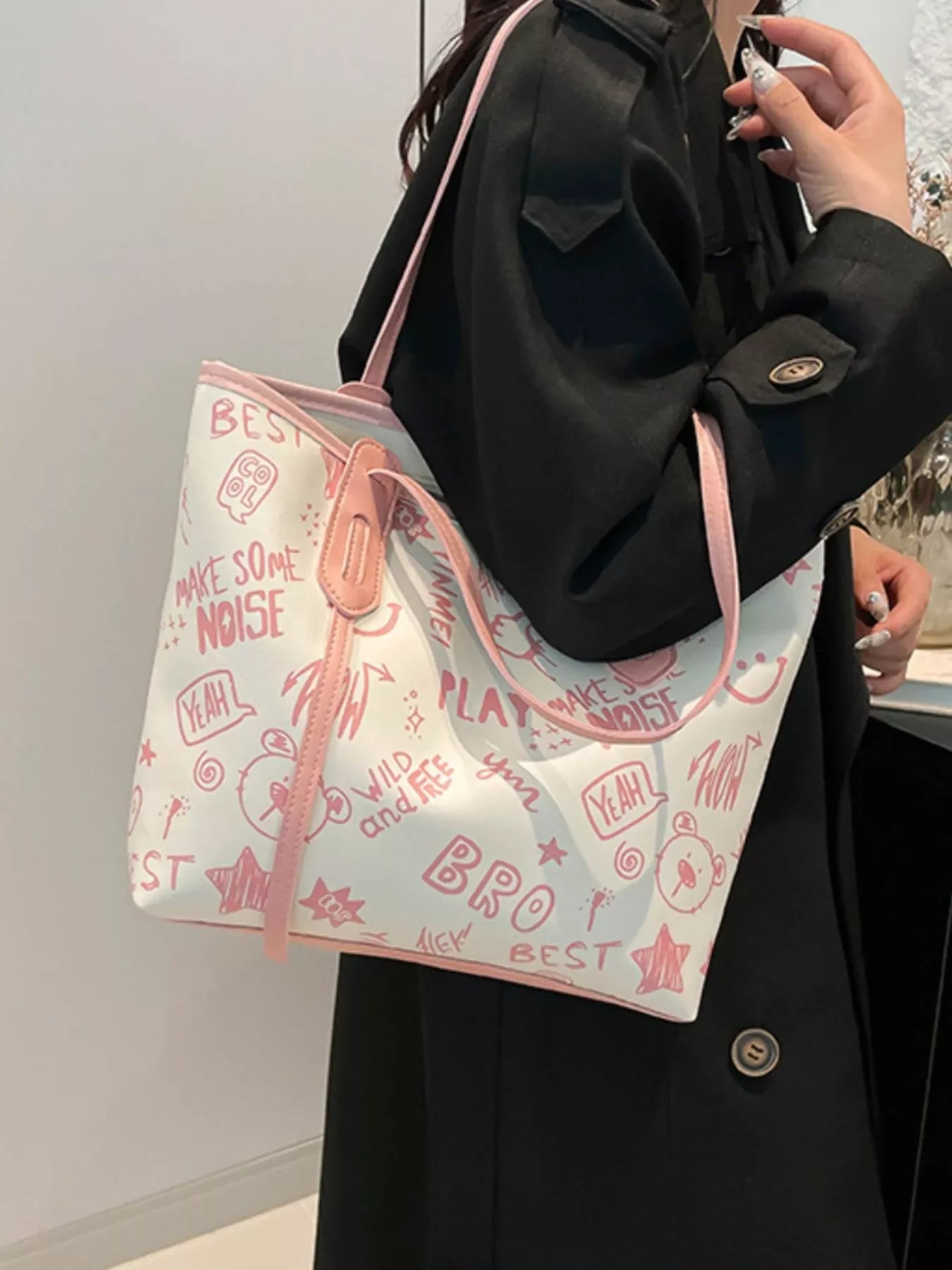 Graffiti Print Tote Bag – Large Canvas Shoulder Bag for Women being carried by a stylish woman in a black coat.