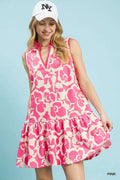 Smiling woman in a pink floral dress for women with a tiered hem and a stylish cap, perfect for summer outings.