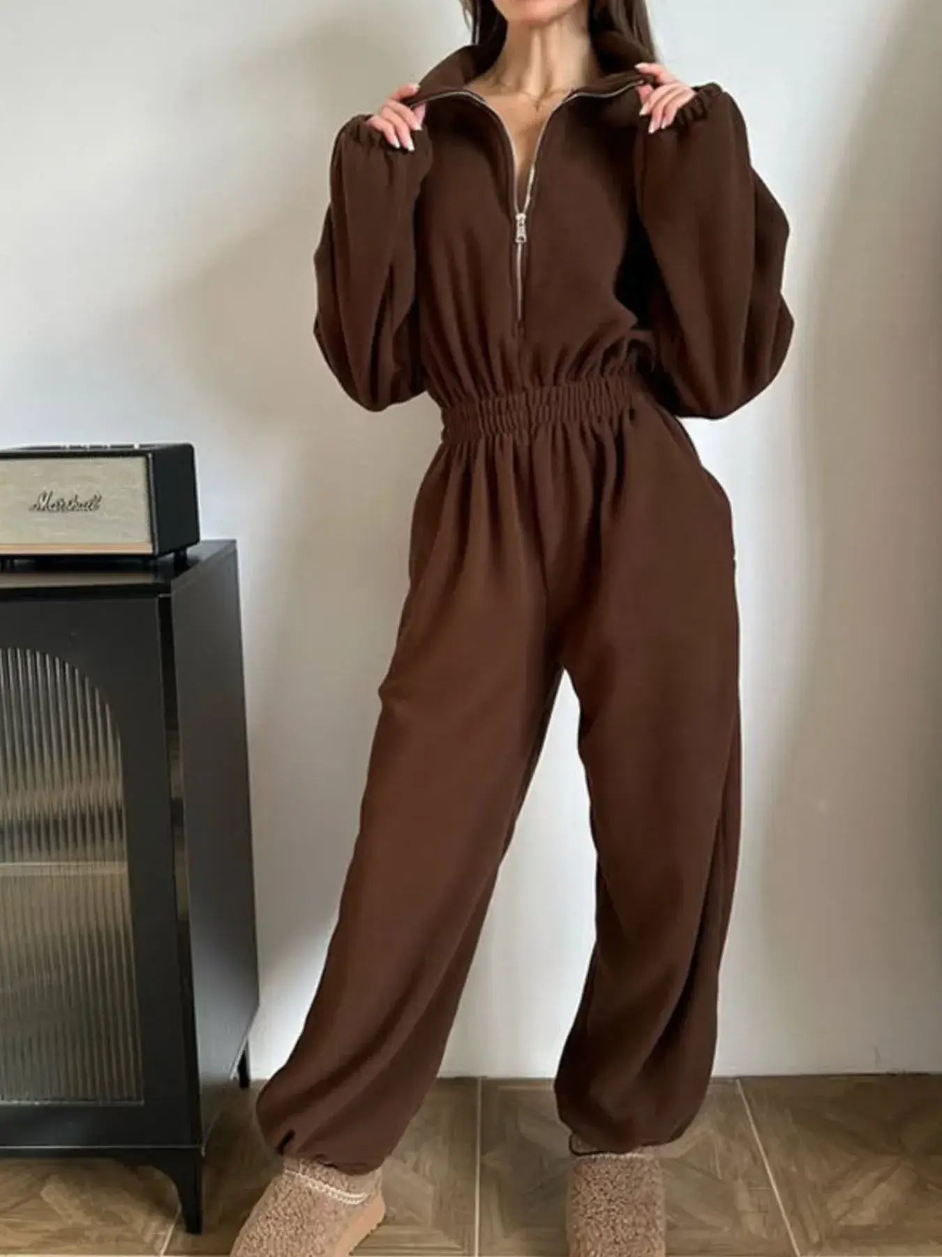 Stylish model wearing a women's jumpsuit zip front long sleeve in brown, showcasing a casual and trendy look.