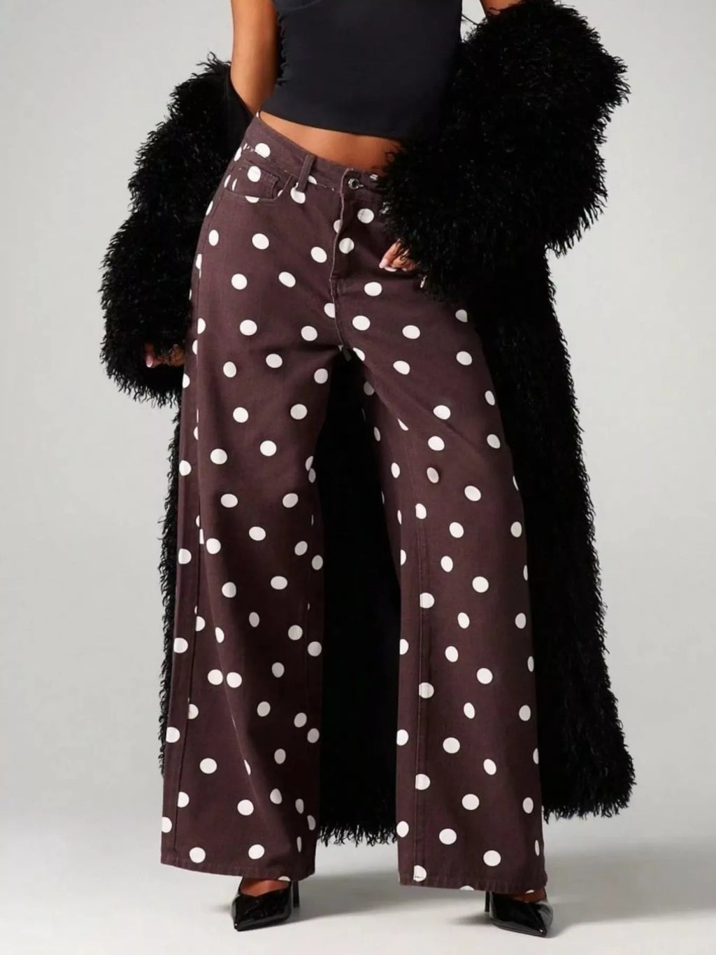 Trendy polka dot wide-leg jeans feature a chic brown color, paired with a stylish black coat, perfect for casual outings.